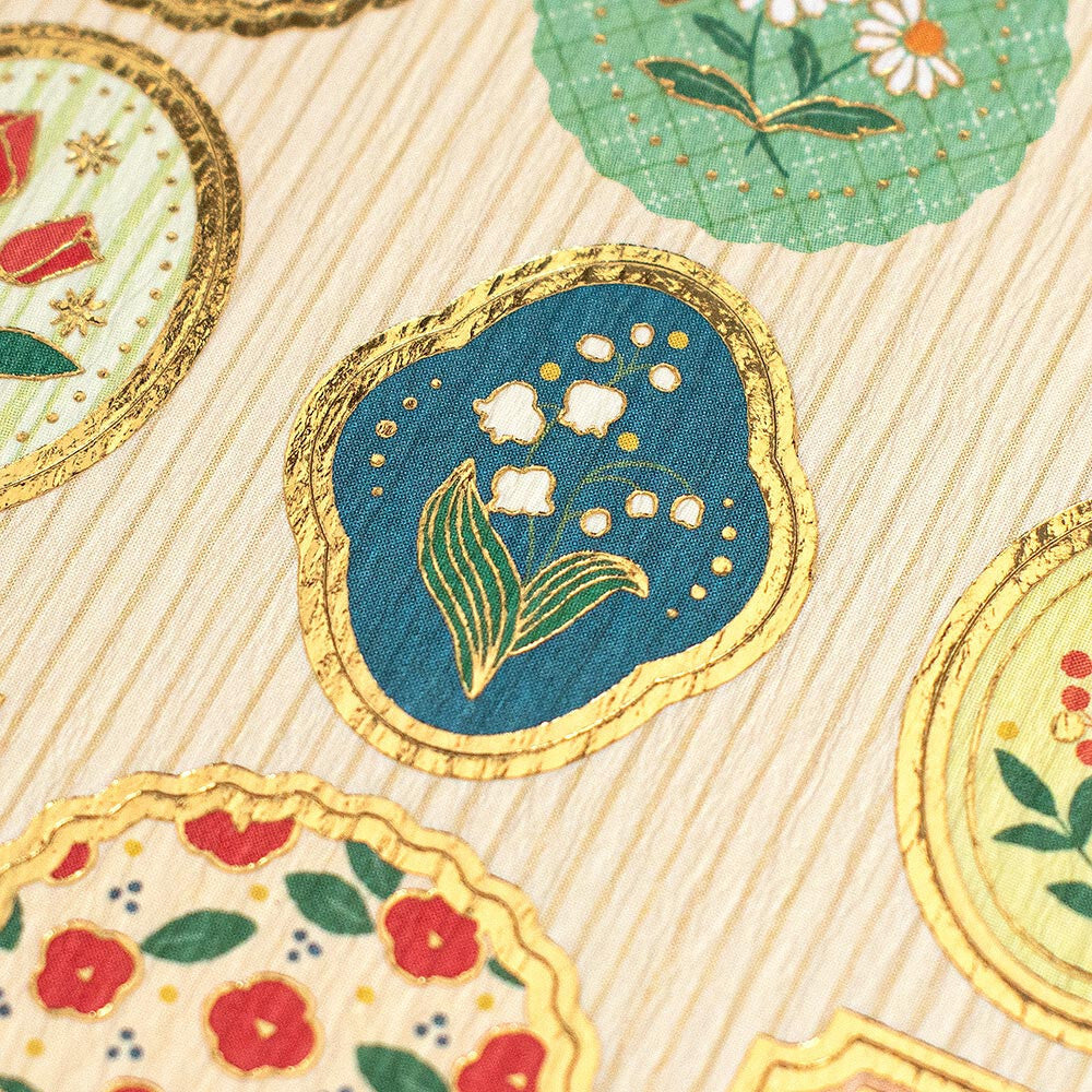 Close-up on a floral sticker with gold foil accents.