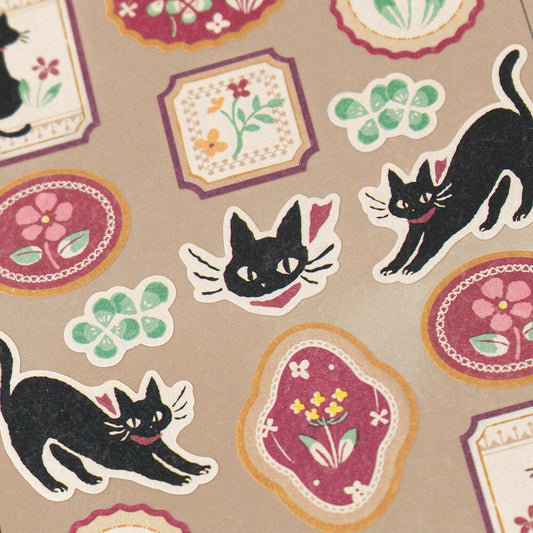 Black Cat and Flowers Sticker Sheet featuring black cat poses and decorative floral oval and square designs on neutral background