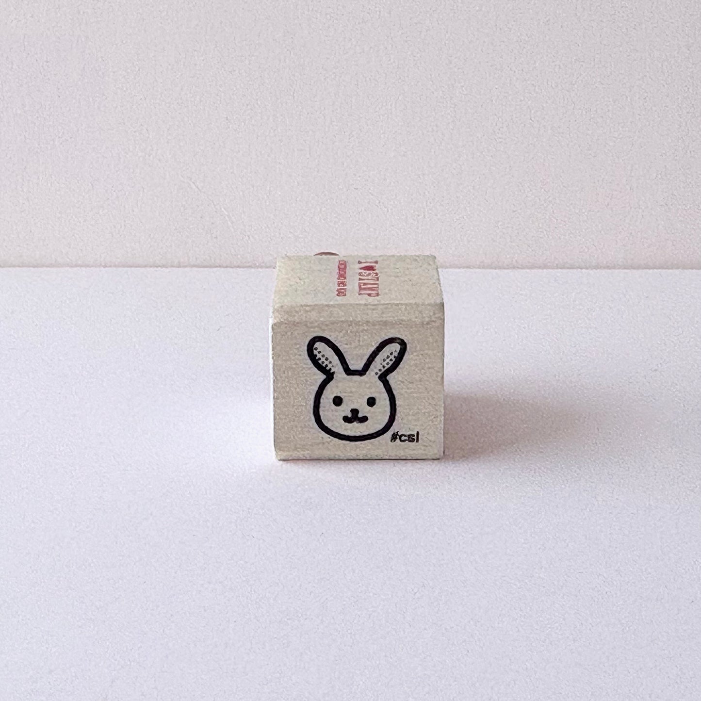 Small cube-shaped stamp with a rabbit design on a white background