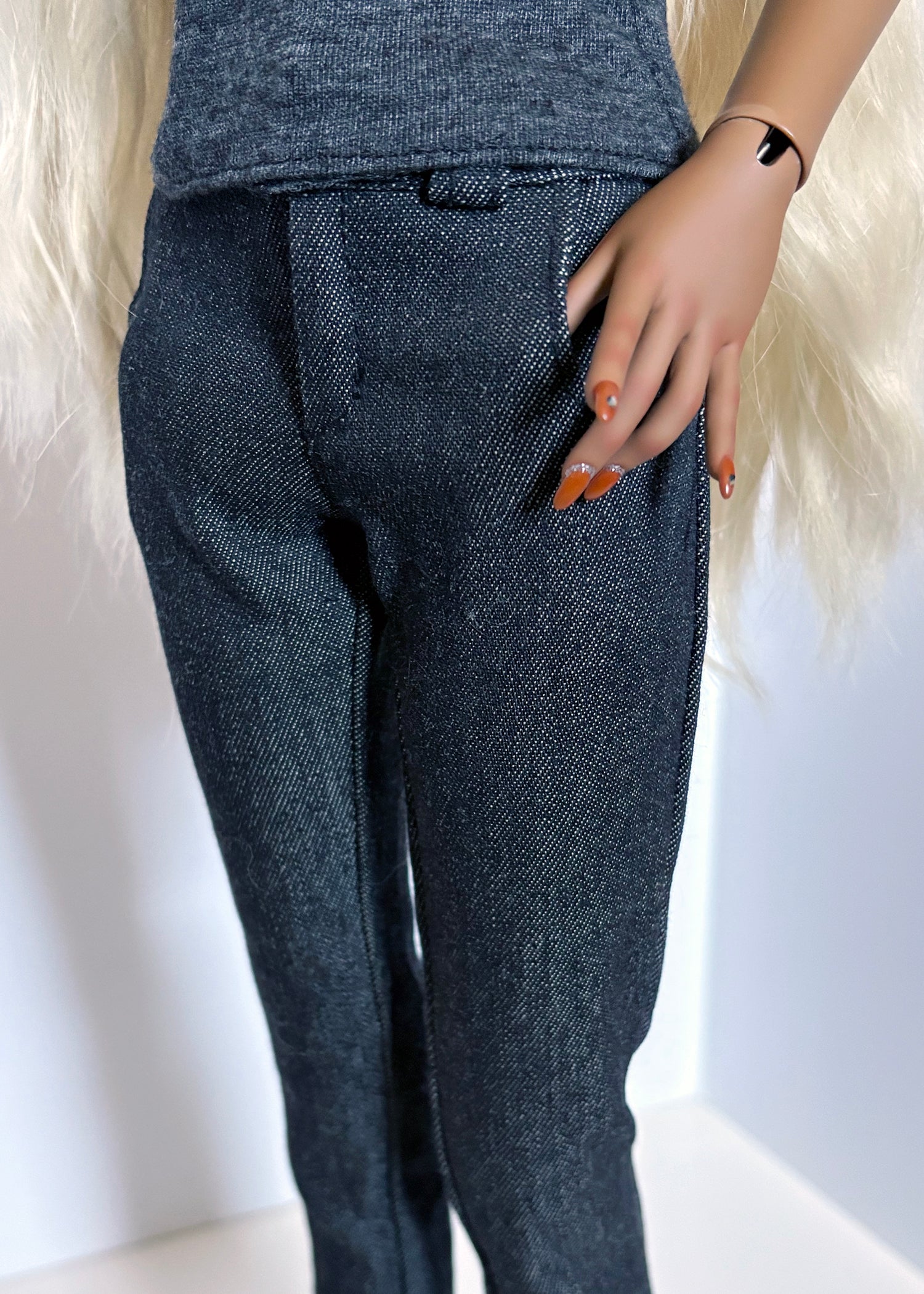 Person wearing dark blue denim pants with a white background