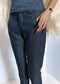 Person wearing dark blue denim pants with a white background