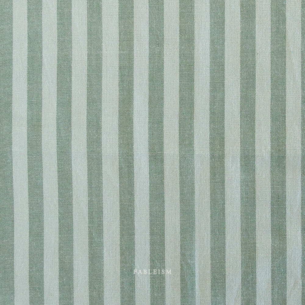 Fabric with vertical light teal and light brown stripes and 'Fableism' branding.