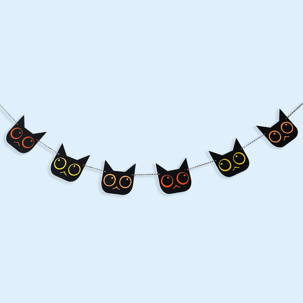 Halloween Black Cat Paper Party Garland featuring black cat faces with colorful eyes on a string for festive decoration