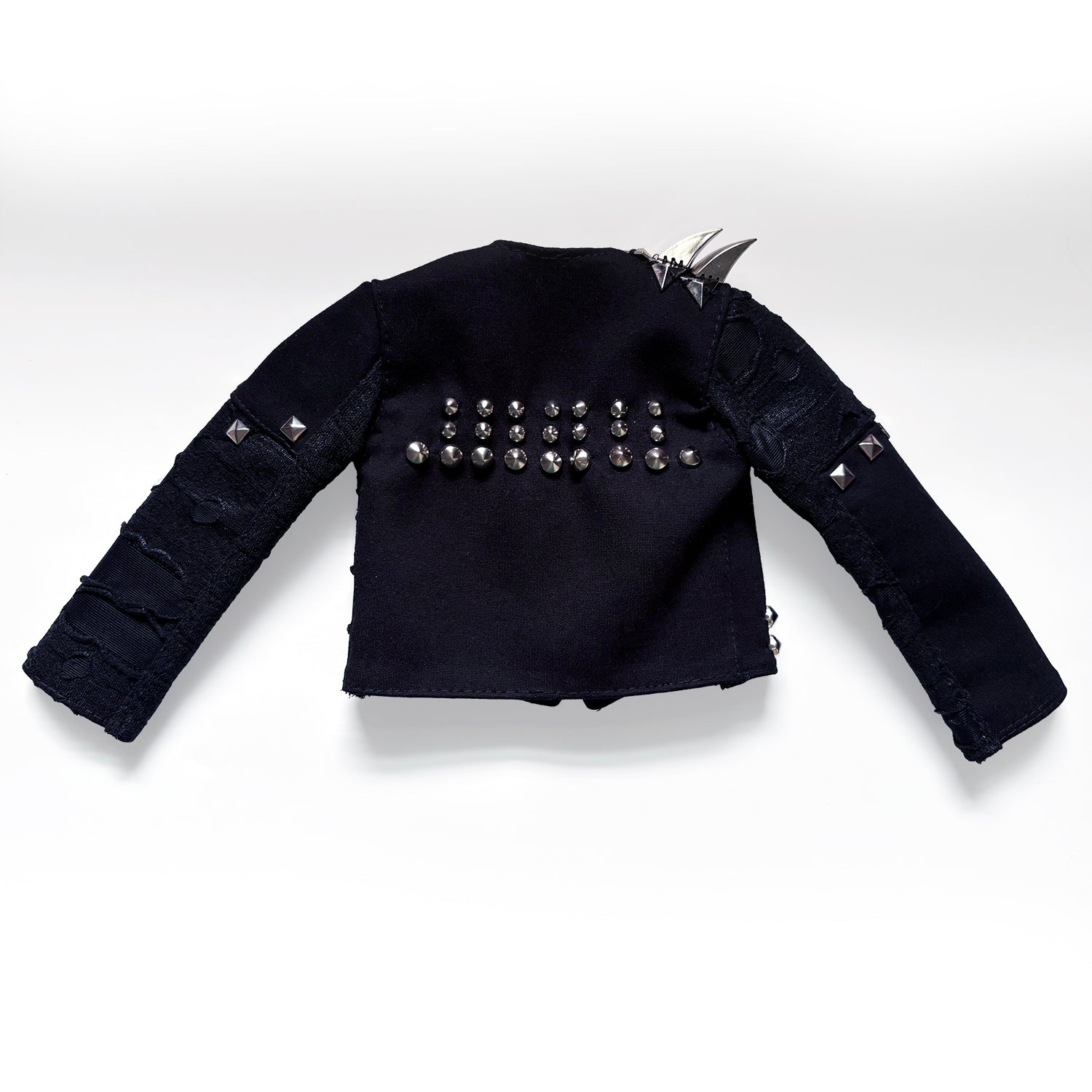 A black studded jacket with distressed details and silver spikes on the shoulders, displayed against a light gray background.