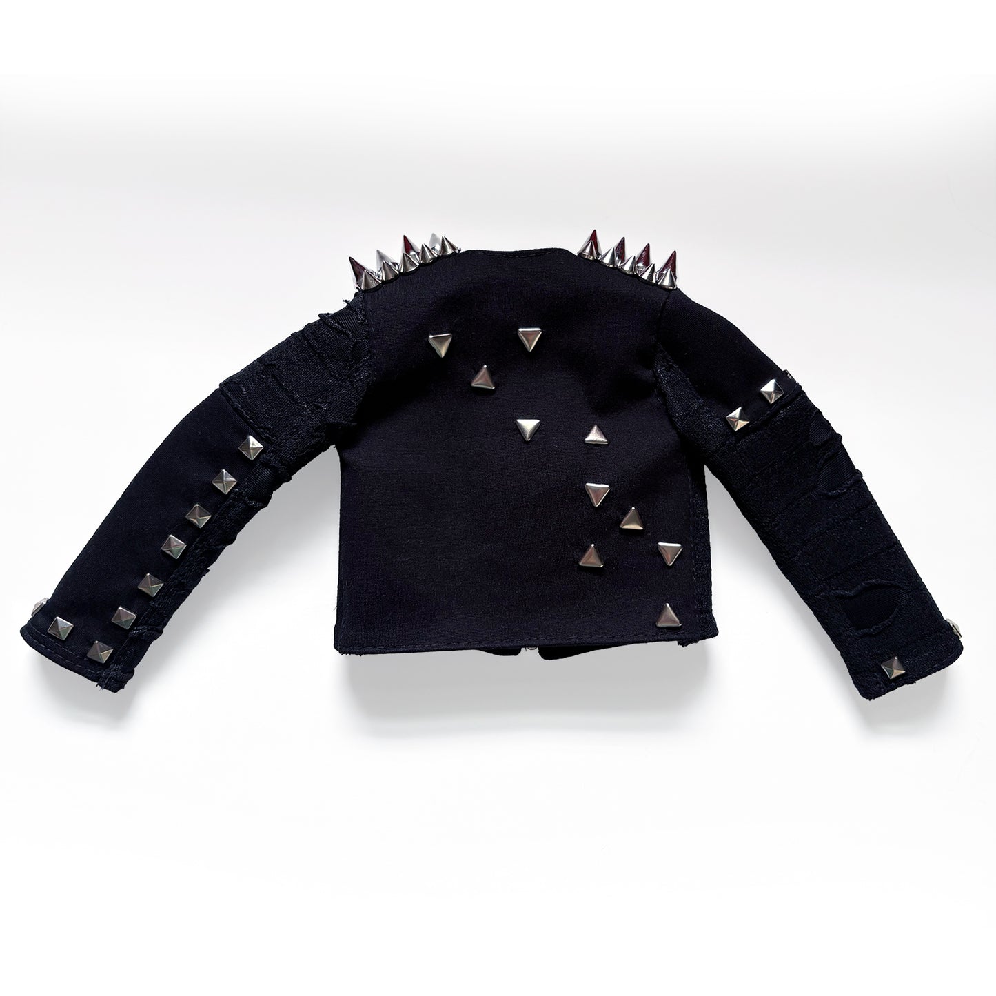 A black long-sleeve cropped jacket with silver pyramid studs, spiked shoulder details, and distressed ripped sections on the sleeves, displayed against a light gray background.