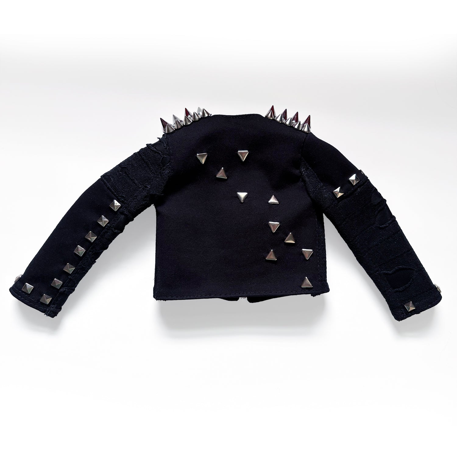 A black long-sleeve cropped jacket with silver pyramid studs, spiked shoulder details, and distressed ripped sections on the sleeves, displayed against a light gray background.
