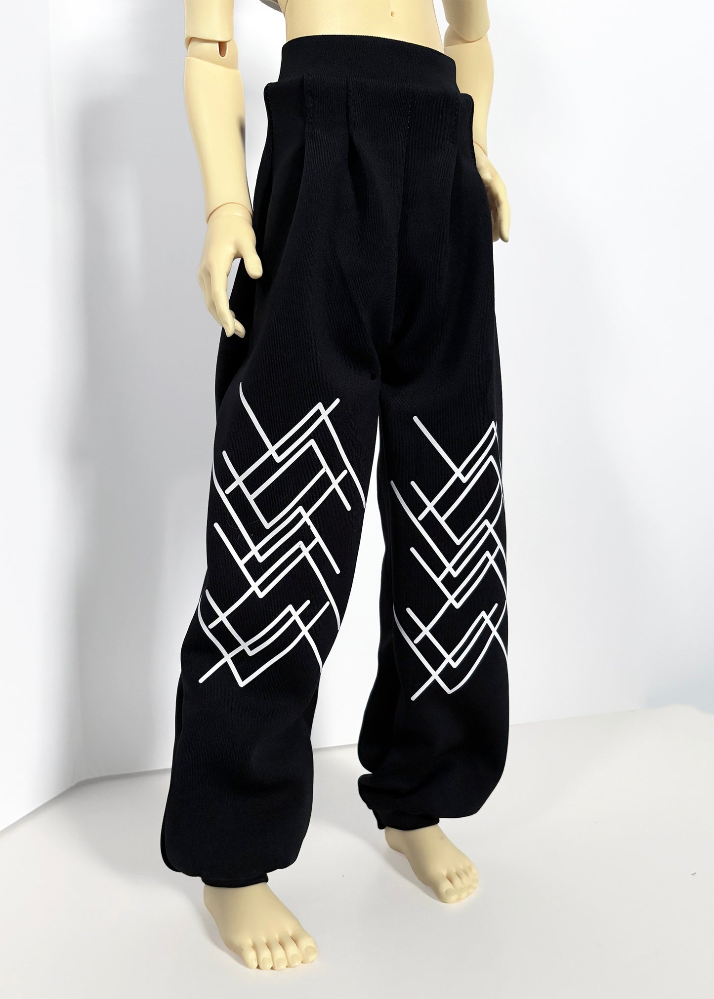 Black wide-leg sweatpants with white geometric line patterns on the lower legs, displayed on a ball-jointed doll against a white studio background.