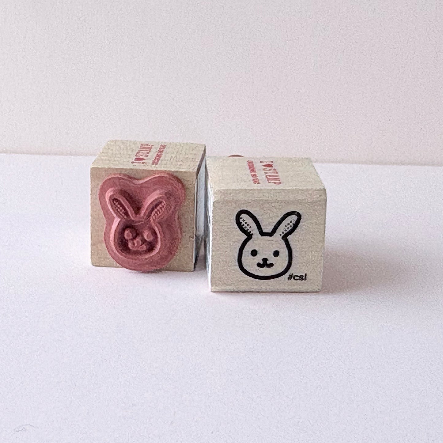 Two wooden stamps with rabbit designs on a white background