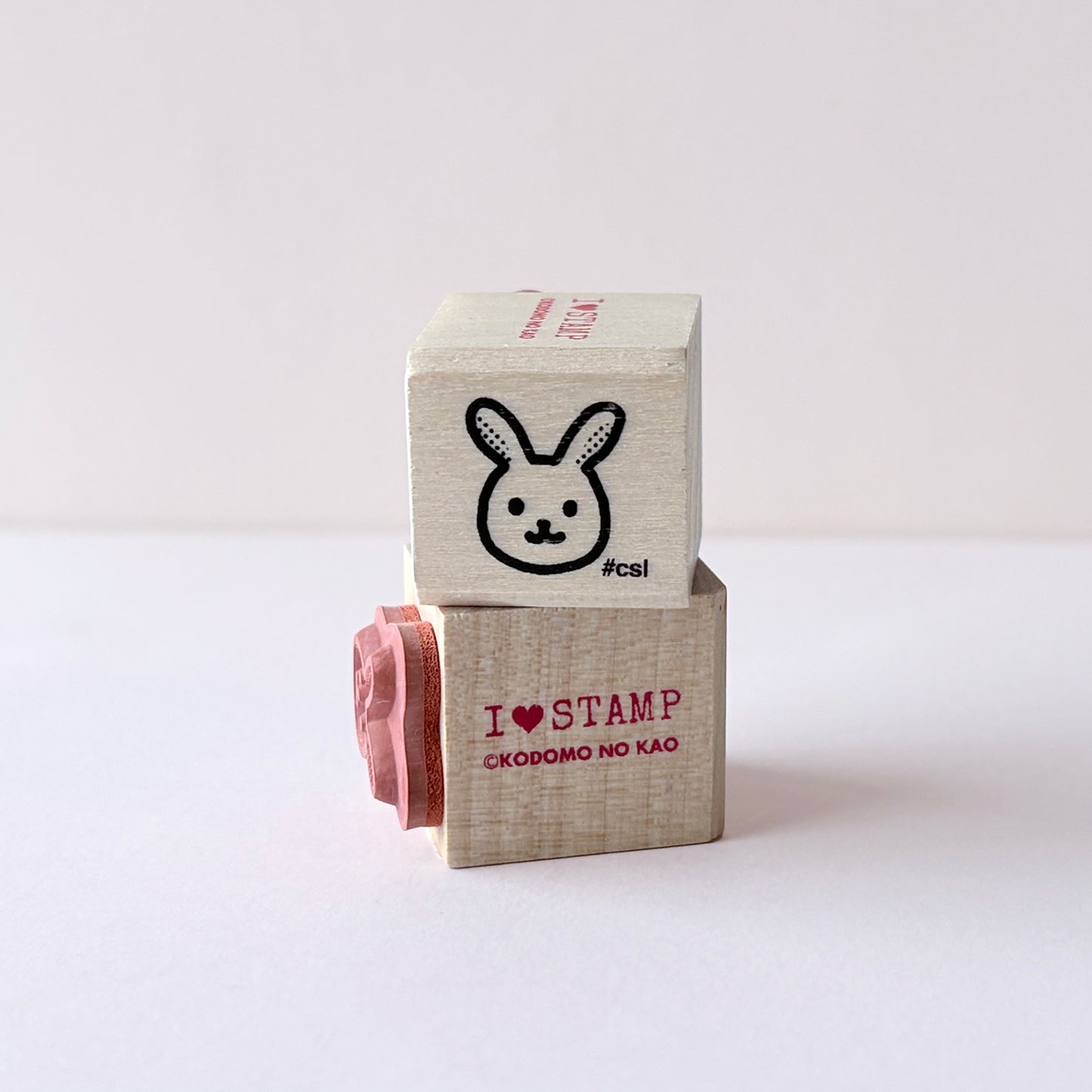 Two wooden blocks: one with a rabbit stamp and the second with 'I love stamp' text on a white background