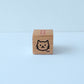 Small wooden block with a cat illustration on a light blue background