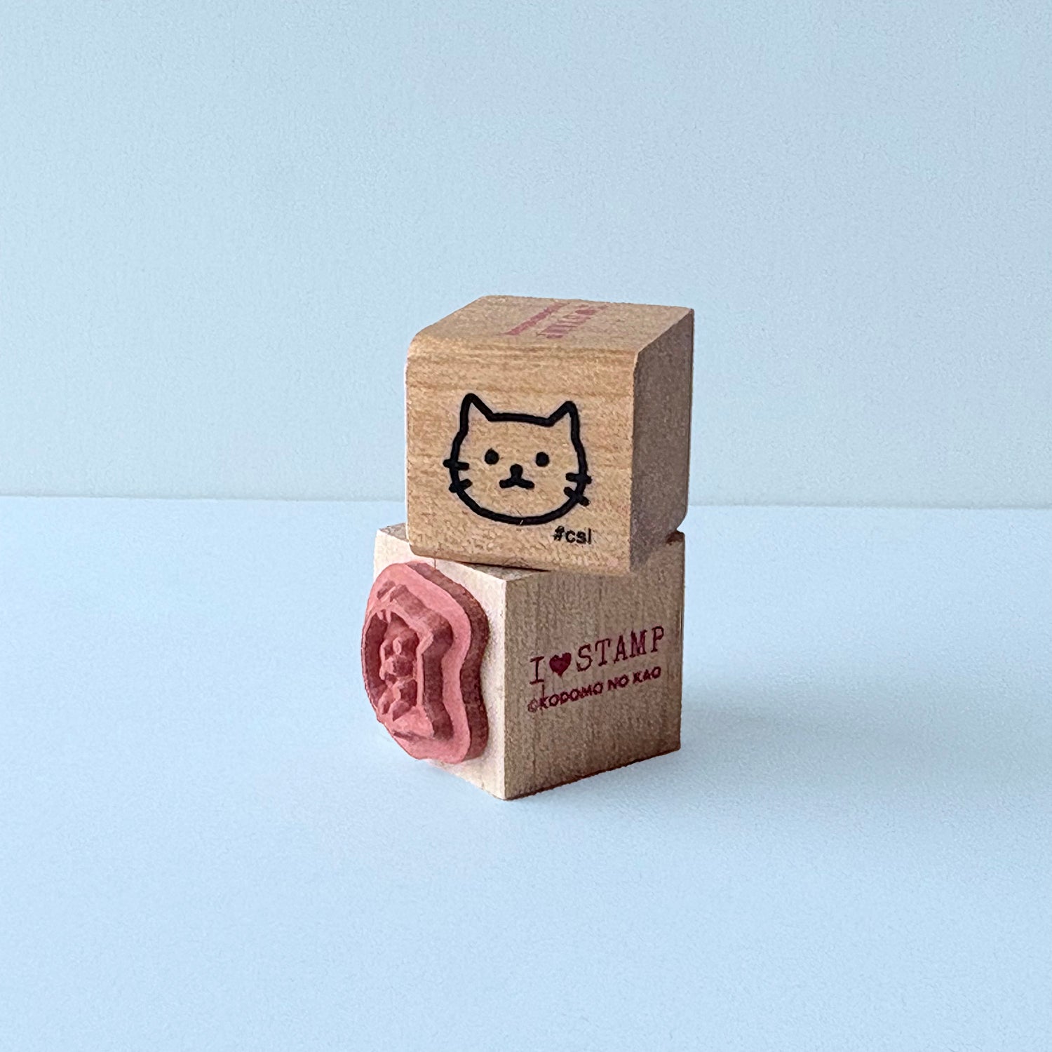 Two wooden stamps with cat designs on a light blue background