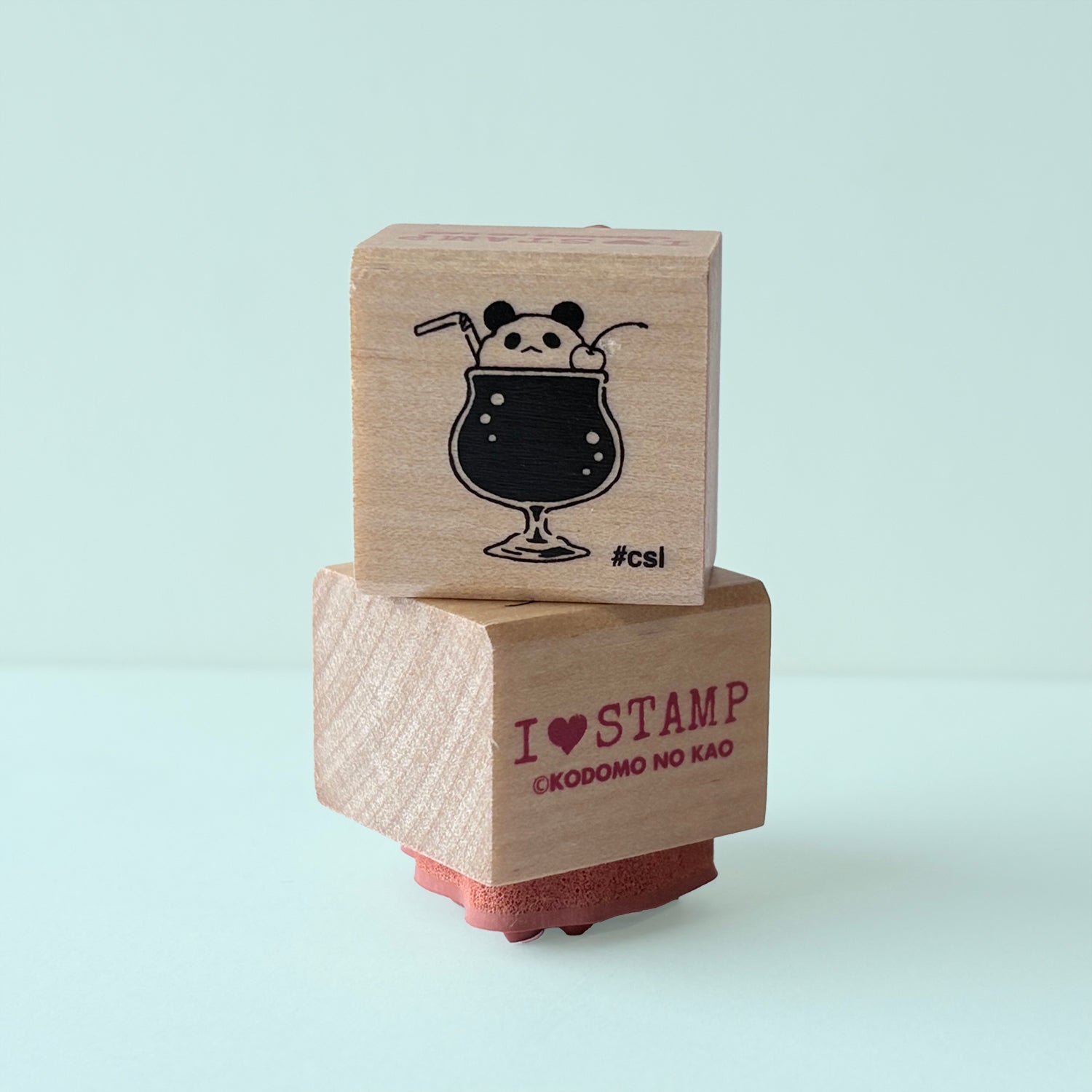 Two wooden stamps with a panda in a glass of soda design and brand name text on a light blue background