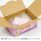 Open cardboard box with a pink product packaging inside, featuring Japanese text.
