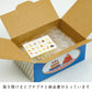 Open cardboard box with a blue design, containing a sheet of stickers on a white background.
