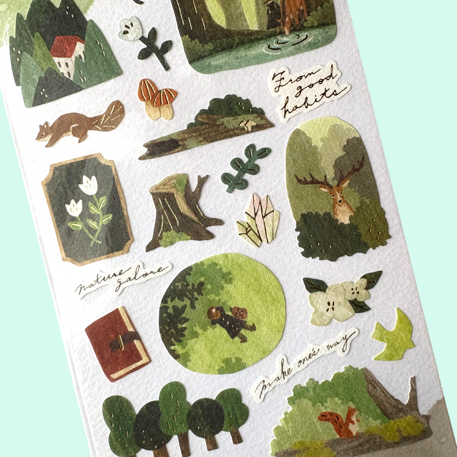 Sheet of nature-themed stickers with illustrations of animals, plants, and landscapes on a light blue background.