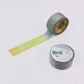 A roll of washi tape with a yellow-to-blue gradient strip unrolled, alongside another roll showing a blue-to-purple gradient, on a plain white background. The label on the bottom-right roll reads 'Rink Washi Tape'.