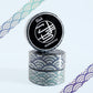 Three rolls of decorative washi tape stacked together, featuring a Japanese wave pattern in teal, blue, and white. The top roll is upright to reveal a black circular label with the brand name 'Rink' and the design name 'KOMACHI'.